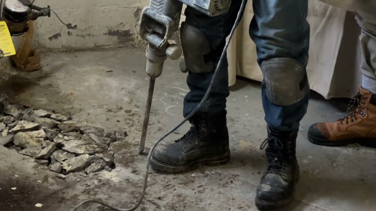 A crew breaking up a basement slab on a renovation.